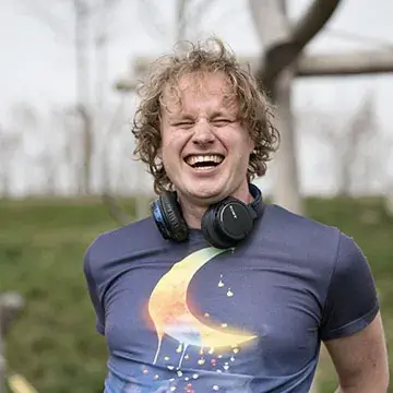 Blijwin, lachend, met koptelefoon om de nek